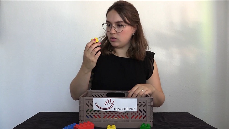 zu sehen ist Sarah Schwarzenberg, die einen Legostein ansieht