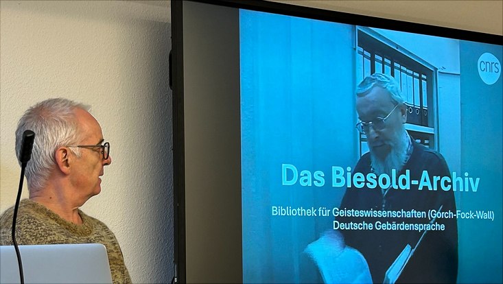 ein Mann schaut auf die Präsentation mit Überschrift "Das Biesold-Archiv"
